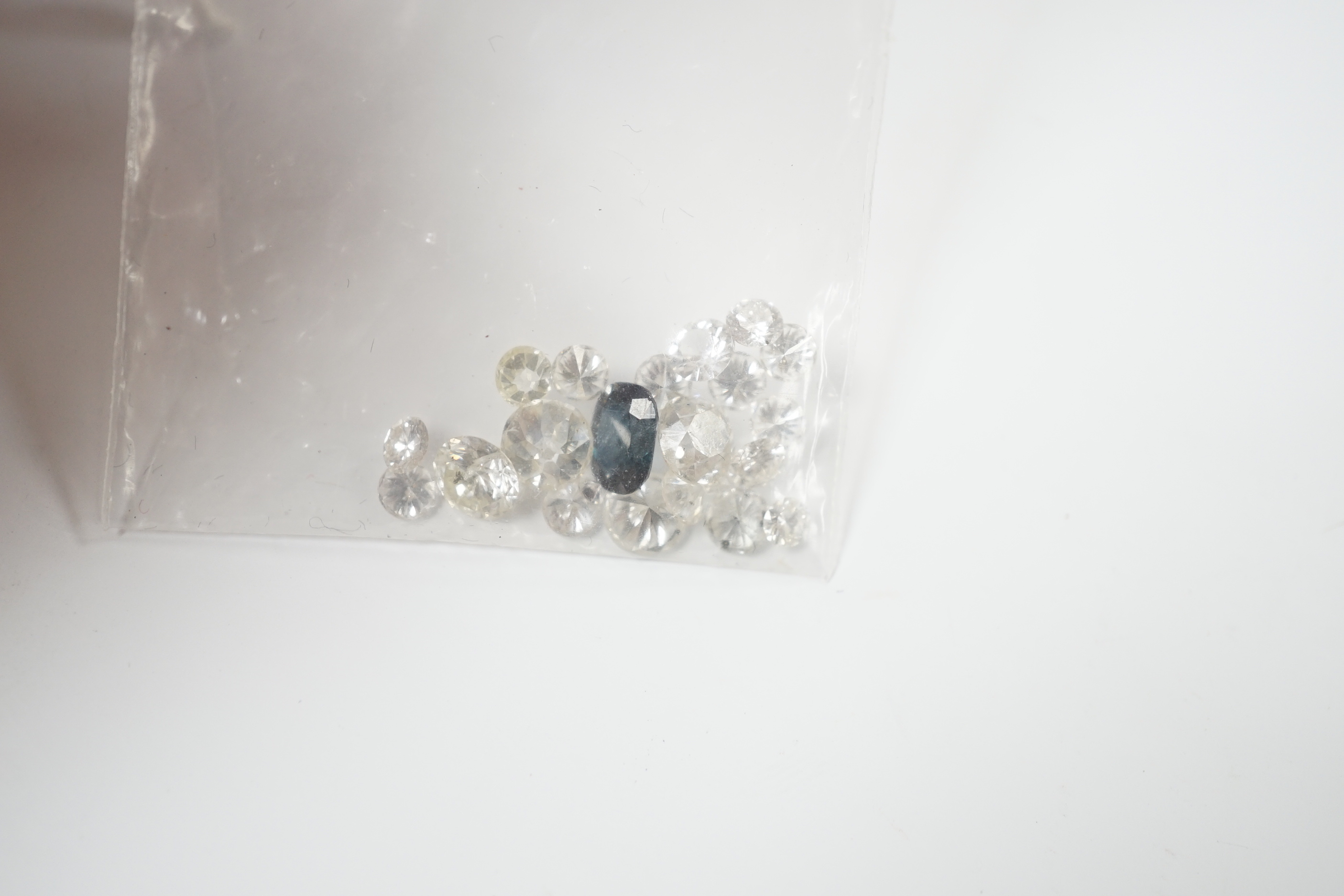 Twenty one unmounted cut diamonds, the four largest stones with an approximate total weight of 2.30ct, together with one unmounted cut sapphire.